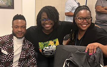 Black Viasat employee at table during STEM event